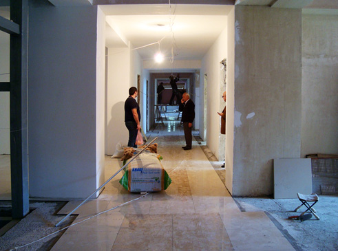 Tchaikovsky school: Workers completing interior finishing of flooring and walls.